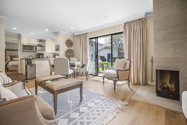 Enjoy cozy evenings by the fireplace in this bright, open-concept living space with large sliding doors that bring the outdoors in.