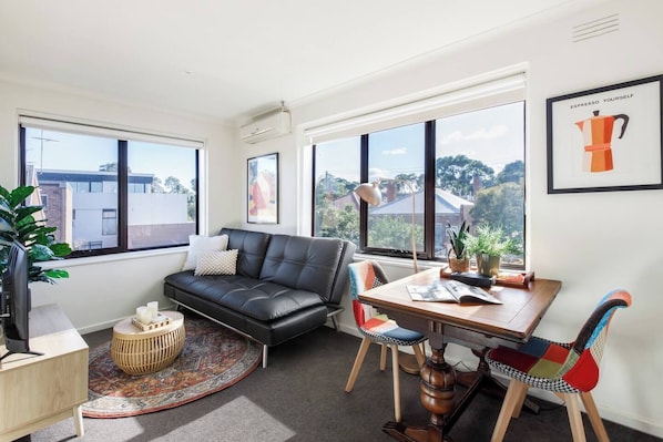 This sunlit living area is perfect for a relaxed evening after exploring nearby neighbourhood gems.