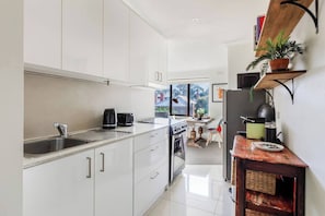 Prepare simple meals or reheat the local tasty takeaway in the compact yet efficient kitchen, fully equipped with a gas cooktop, oven, microwave, Nespresso machine, and all the essentials for a fuss-free stay.