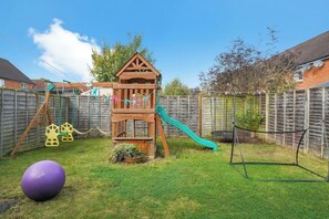 Children's play area with bouncing ball, trampoline well maintained garden 