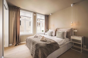 The bedroom boasts large windows, letting in plenty of natural light.