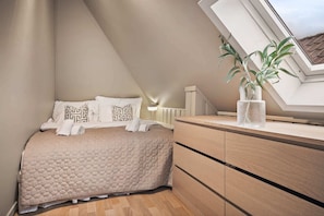 A cozy attic bedroom, featuring minimalist design with a neutral color scheme.