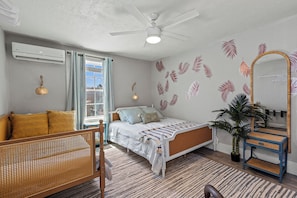 Bedroom with couch, queen bed, air conditioning, and ceiling fan