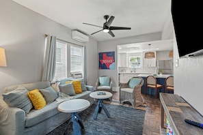 Plush couch, TV, amd ceiling fan in the living room