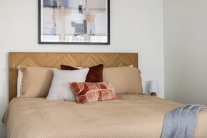 Welcome to your cozy retreat! This serene bedroom offers a plush bed with soft linens, warm lighting, and vaulted ceilings that create a spacious and inviting atmosphere. Perfect for a restful night's sleep or unwinding in comfort after a day of exploring.