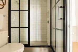 Experience luxury in the modern bathroom with a sleek walk-in shower. Immerse yourself in a refreshing and invigorating showering experience. The contemporary design and top-notch amenities ensure a comfortable and convenient stay.