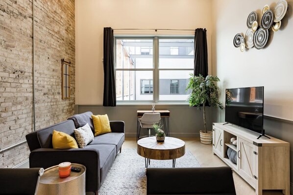 Experience comfort & style in this cozy living room inside the historic Mercantile building on Morris Ave. Fully equipped kitchen, modern decor, and access to amenities. Message us about our concierge services and locally curated experiences