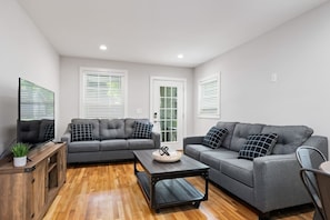 A seamless flow from the living room to the kitchen, highlighted by sleek, modern decor and a comfortable seating area perfect for socializing and relaxation.