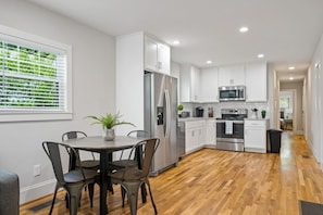 This view highlights the kitchen's expansive countertops and the adjacent dining area, emphasizing space and functionality.