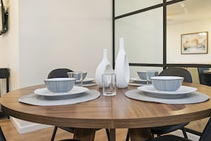 Dine comfortably at the table for four, enhanced by a chic mirrored wall that adds space and elegance to your culinary adventures.