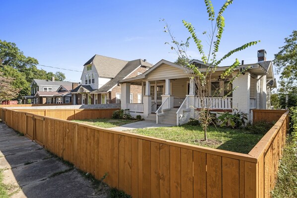 This charming property features a duplex each unit adorned with its own unique design and color palette. Nestled under a clear blue sky, these inviting houses include cozy porches and are partially enclosed and equipped with games (like foosball!)