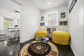 Step into a cozy game room adorned with two inviting yellow bean bag chairs, perfectly placed to enjoy a board game, play on the Wii, or watch TV.
