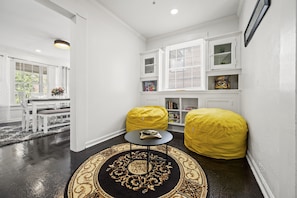 Step into a cozy game room adorned with two inviting yellow bean bag chairs, perfectly placed to enjoy a board game, play on the Wii, or watch TV.