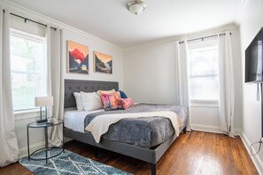 Peaceful bedroom with cozy bedding, mountain art, and natural light for a restful night’s sleep.