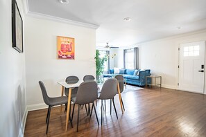 Open layout with dining for six and a plush blue sofa—perfect for meals and movie nights.
