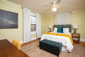 This spacious bedroom features a large area with ample room to move around. It also includes a dedicated workspace, perfect for productivity. The clean, minimalist design creates a calm, functional environment for both relaxation and work.