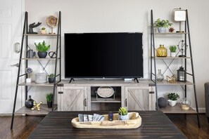 Entertainment center with a smart TV, bookshelves, and thoughtful decor for relaxing evenings. 