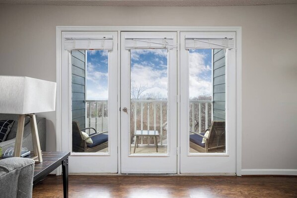 Balcony doors open to reveal a private outdoor seating area, perfect for enjoying fresh air and city views.