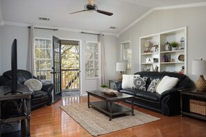 Living Room with Natural Light: A beautifully lit living room with large windows offering serene views.