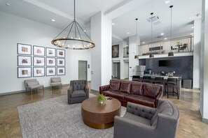 Stylish common lounge with chic furnishings, a modern chandelier, and a welcoming atmosphere.