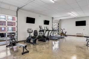 Fully equipped fitness center with a range of exercise machines and an open layout.