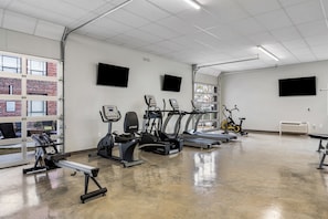 Fully equipped fitness center with a range of exercise machines and an open layout.