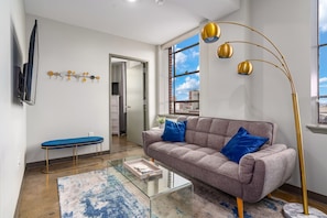 Bright and inviting living room with chic decor and natural light from large windows.