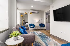 Bright and modern living room with stylish decor, comfortable seating, and a flat-screen TV.