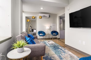 Bright and modern living room with stylish decor, comfortable seating, and a flat-screen TV.