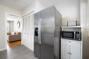 Spacious kitchen with a side-by-side refrigerator, built-in microwave, and plenty of counter space for cooking and dining.