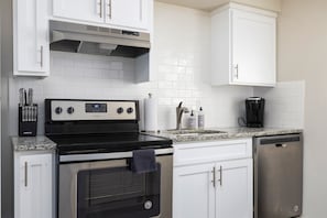 A closer look at the modern stove, dishwasher, and countertop space, making meal prep a breeze.