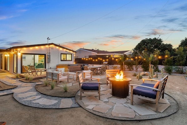 Welcome to the yard of your dreams: hot tub, fire pit, and multiple lounge areas surrounded by beautiful citrus, palms, agaves and cactus