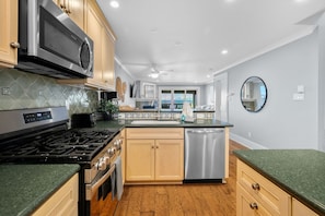 Updated kitchen features eye-catching green granite countertops, stainless steel appliances, and all the essentials to make meal prep a breeze.