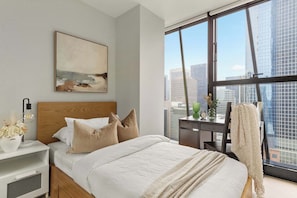 The 2nd bedroom with a single sized bed & plush pillows.