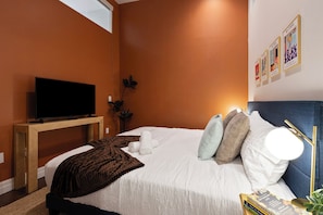 King-size bed w/ 43" Smart TV and closet w/ hangers and clothing storage.