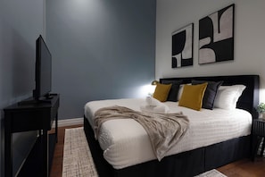King-size bed w/ 43" Smart TV and closet w/ hangers and clothing storage.