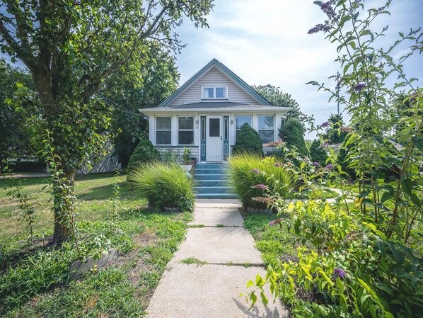 This charming home features a beautifully landscaped front yard with a welcoming pathway leading to the inviting entrance.