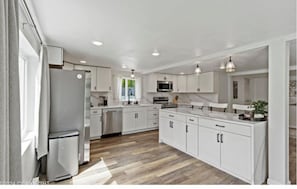 Large home kitchen has all the basic supplies for cooking and dining.