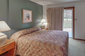 The primary bedroom offers a comfortable queen bed and direct patio access for fresh mountain air.