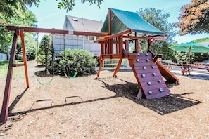 The outdoor playground features swings and climbing structures, providing a safe and enjoyable space for children to play.