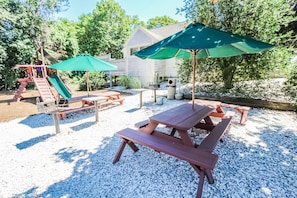 The family-friendly BBQ area offers picnic tables and a playground, creating the perfect setting for outdoor meals and joyful playtime.