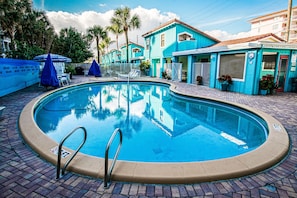 Enjoy sun-soaked days by the resort pool, beautifully surrounded by palm trees and tranquil seating areas, perfect for relaxation.