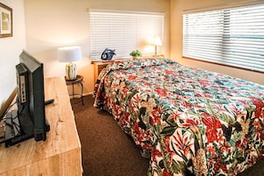 The inviting guest bedroom offers a charming atmosphere with comfortable bedding and a Smart TV, perfect for unwinding after a day at the beach.