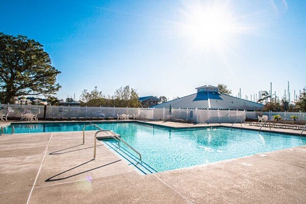 Dive into family fun at this inviting outdoor pool, set against a radiant blue sky, perfect for relaxing days by the riverside.