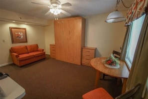 Experience cozy living with a queen Murphy bed, a loveseat for lounging, and a dining table for two in your beachside retreat!