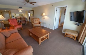 This inviting living space is designed for comfort, featuring a smart TV and easy access to a full kitchen and dining area, making it a perfect home away from home.