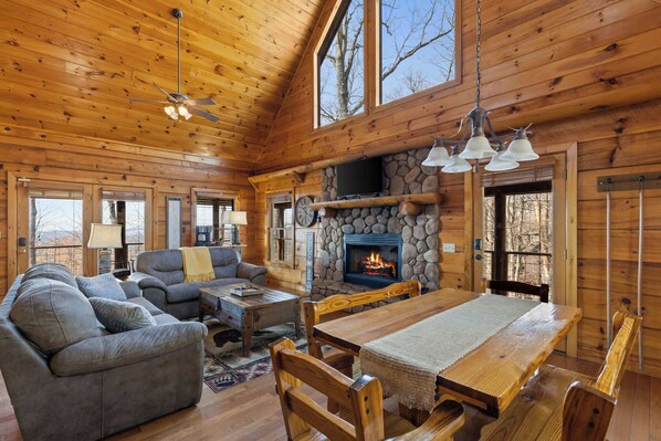 Enjoy the spacious charm of vaulted ceilings in this cozy cabin living room, where comfort and style meet the great outdoors.