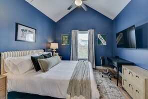 Bedroom 2: Relax and recharge in this stylish queen bedroom featuring cozy linens, a Smart TV, and a modern lamp for the perfect ambiance. 