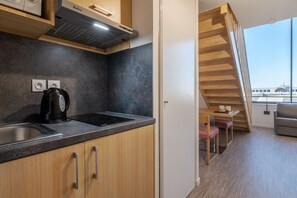A well-organized kitchenette with modern appliances seamlessly integrated into a functional living area.