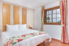 Bright and welcoming bedroom with cheerful floral accents, offering a peaceful retreat.